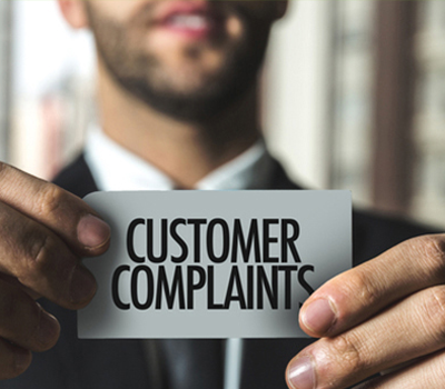 Man holding consumer complaints sign